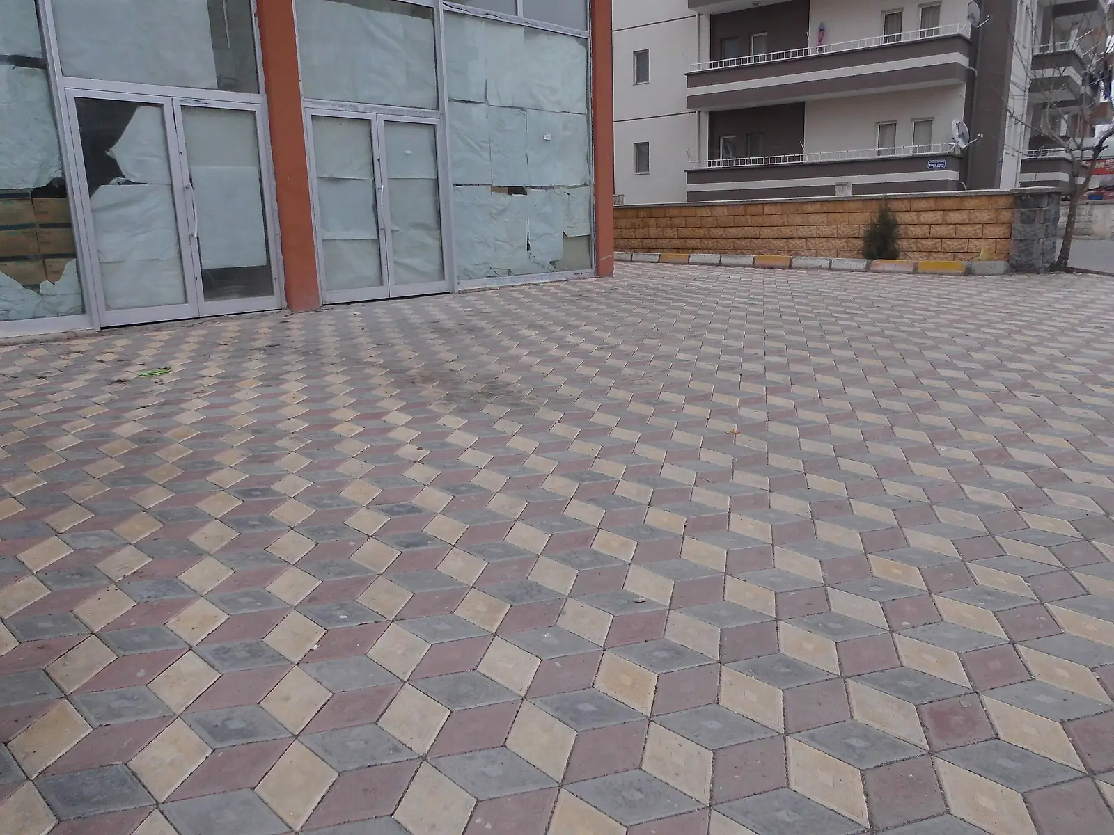 Apartman girişinin önüne döşenmiş, üç boyutlu küp desenli renkli karo