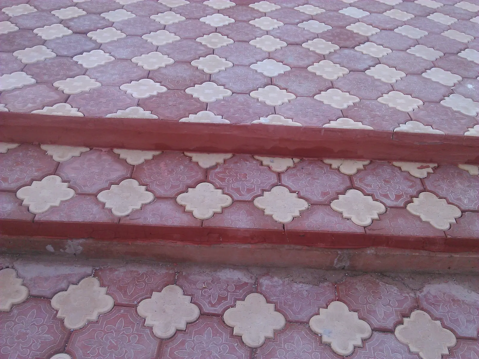 Bordo ve krem yonca karo döşenmiş merdiven basamakları ve sahanlık