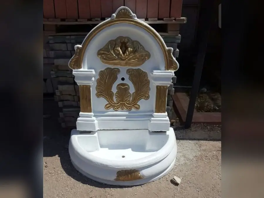 Beyaz zemin üzerine altın yaldız bezemeli, kemerli beton duvar çeşmesi