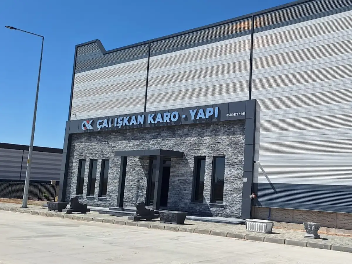 Üretim binasının önünde paletler halinde istiflenmiş beton karo ve parke taşı stoğu