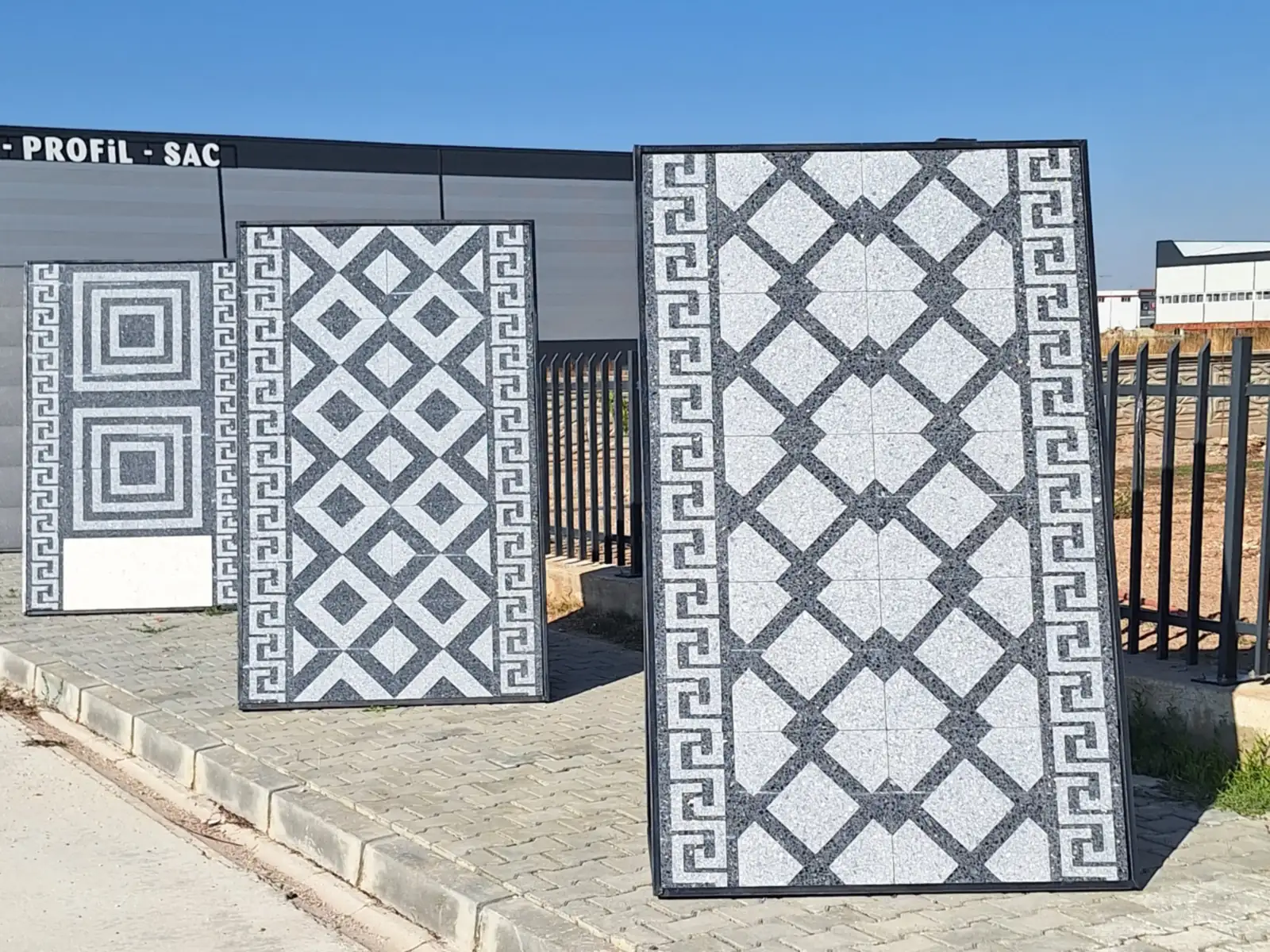 Yeni tesiste çite dayalı, meander bordürlü kare, baklava ve çapraz kafes desenli mozaik karo panoları