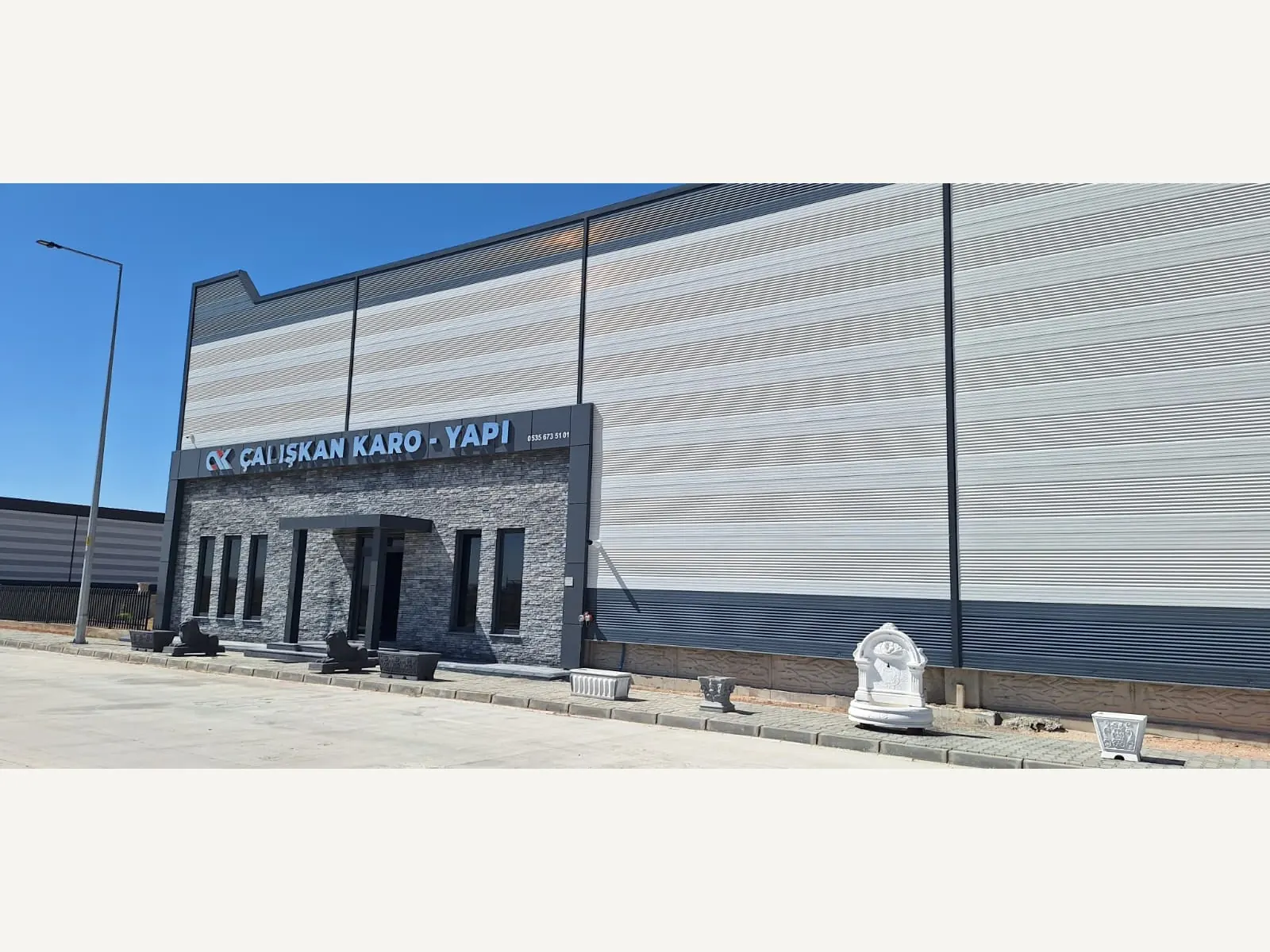 Üretim binasının önünde paletler halinde istiflenmiş beton karo ve parke taşı stoğu